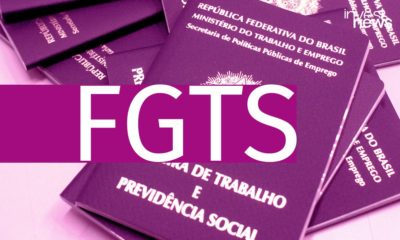A imagem mostra algumas carteiras de trabalho empilhadas umas sobre as outras. Há uma faixa roxa sobre a foto, com a sigla FGTS escrita em branco.