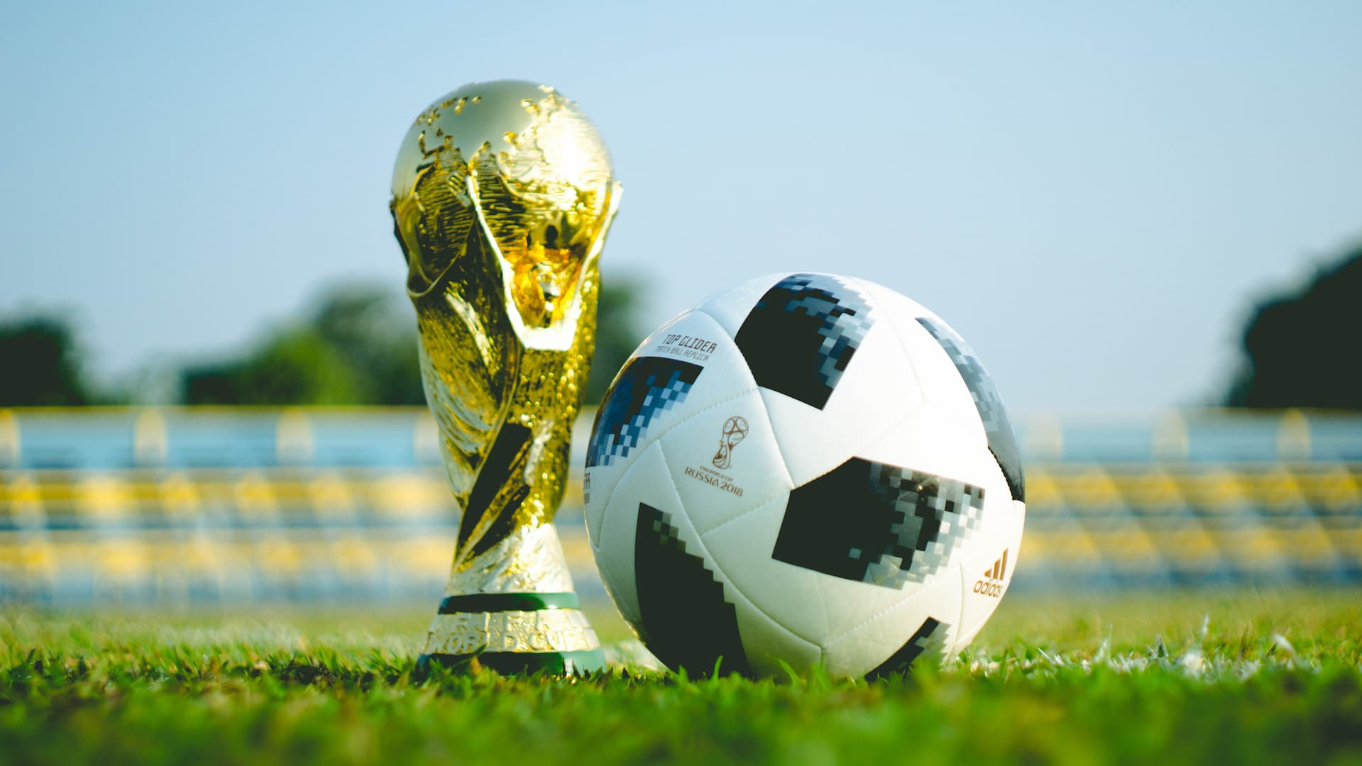 Taça da copa do mundo ao lado de uma bola de futebol
