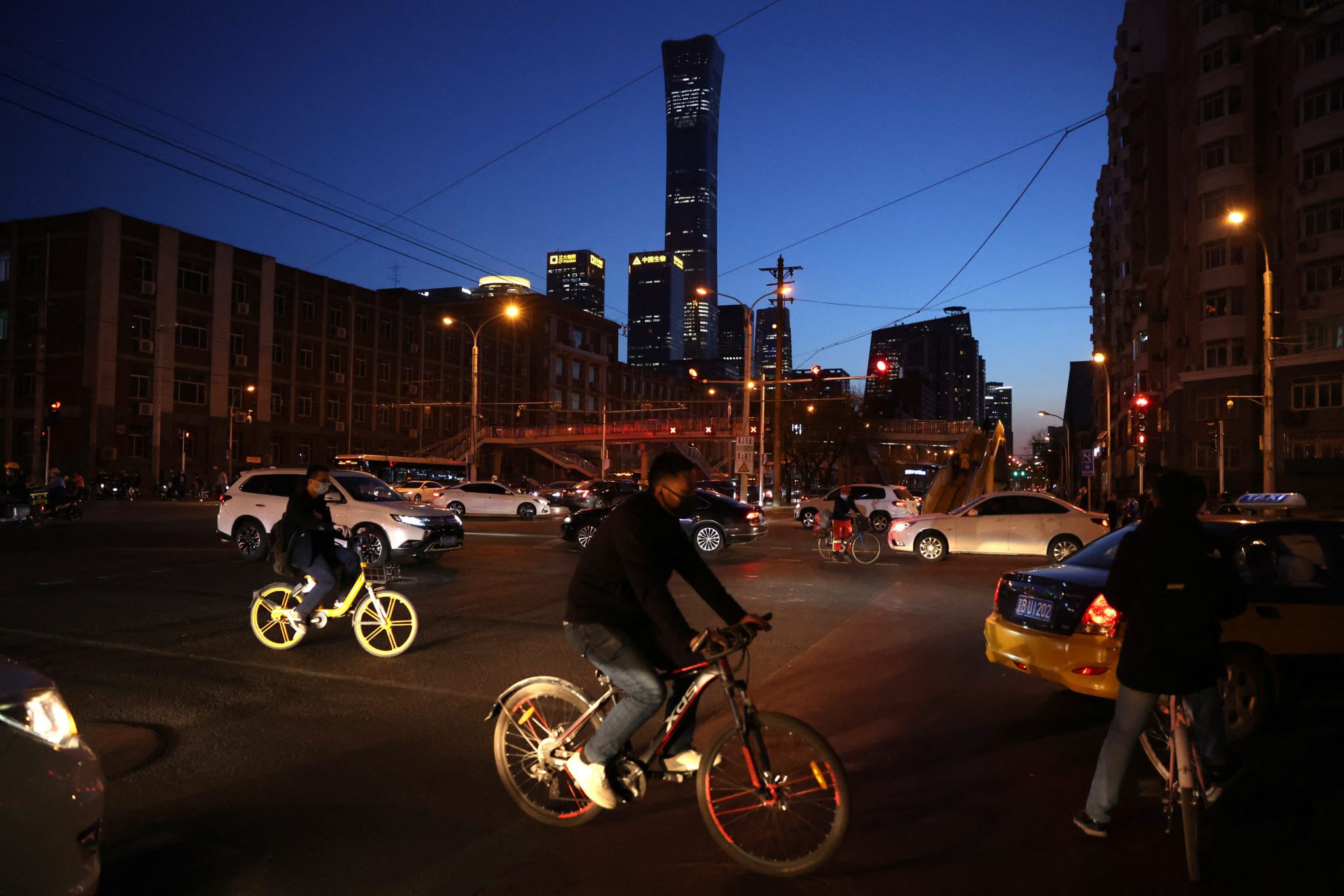 Pessoas andam de bicicleta em rua de Pequim