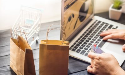 Pessoa faz compra online segurando cartão de crédito