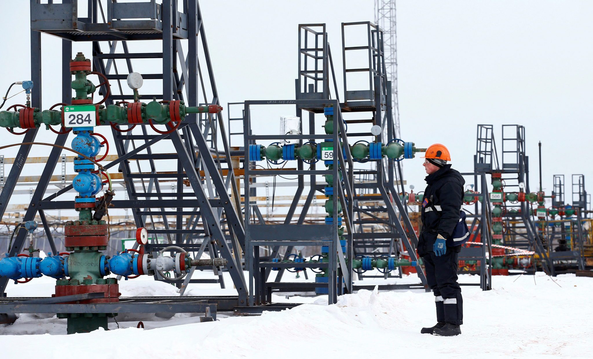 Funcionário inspeciona cabeça de poço no campo de petrróleo de Yarakata, na região russa de Itkutsk