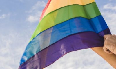 cropped-man-with-big-flag-in-lgbt-colors-and-blue-sky.jpg