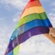 cropped-man-with-big-flag-in-lgbt-colors-and-blue-sky.jpg