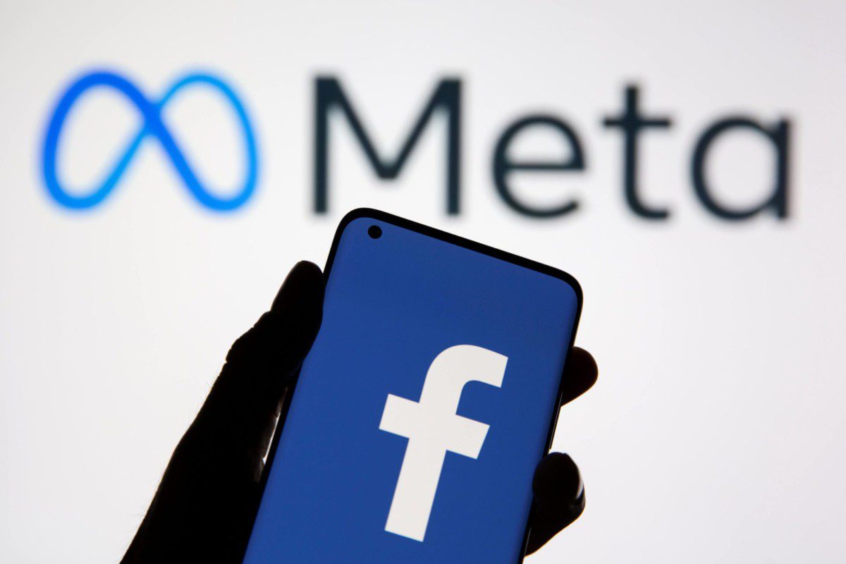 Mão segurando um celular com logo do Facebook, ilustrando o tema: história do facebook