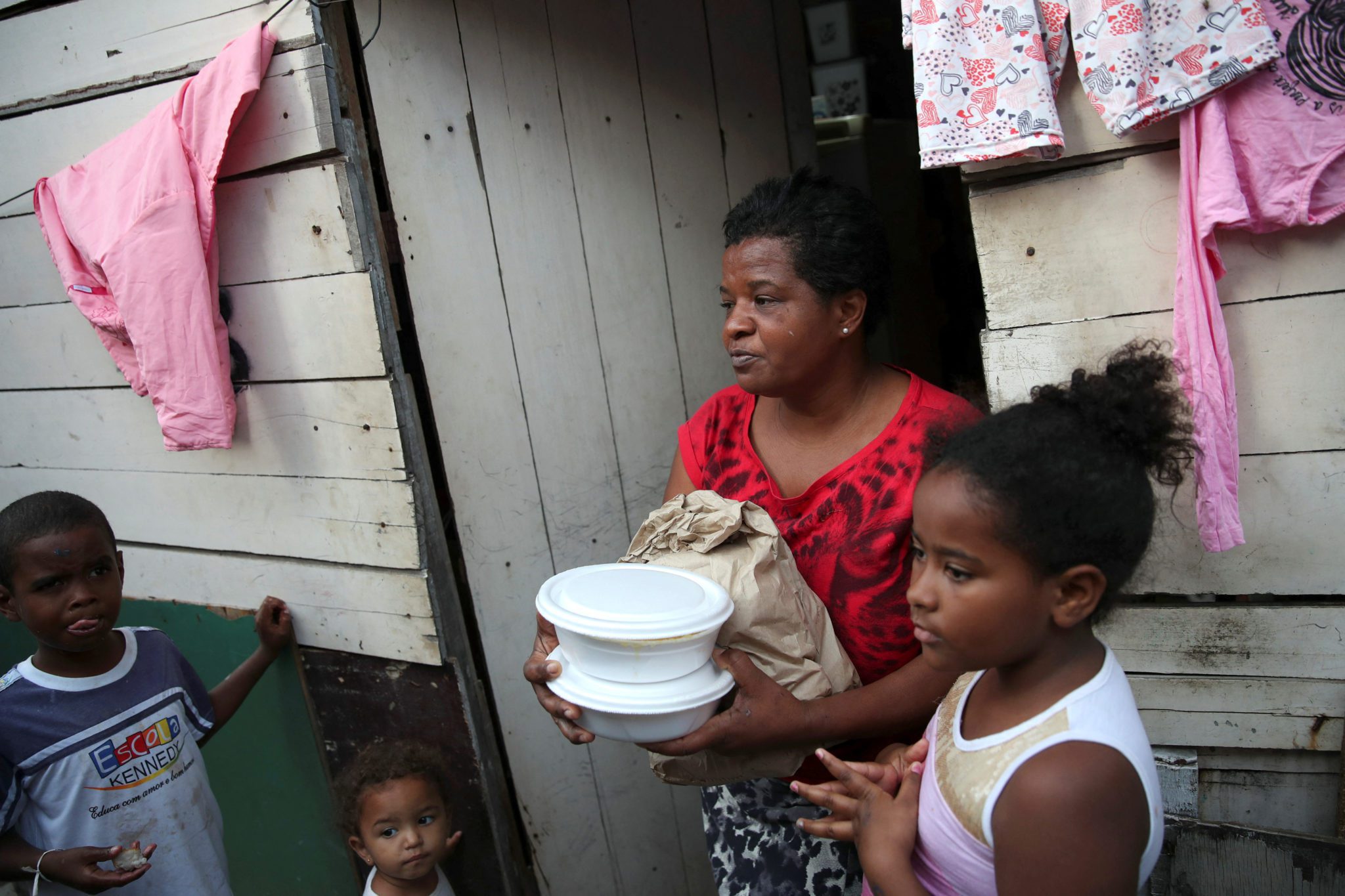 Voluntários de uma igreja distribuem comida em favela no Rio de Janeiro