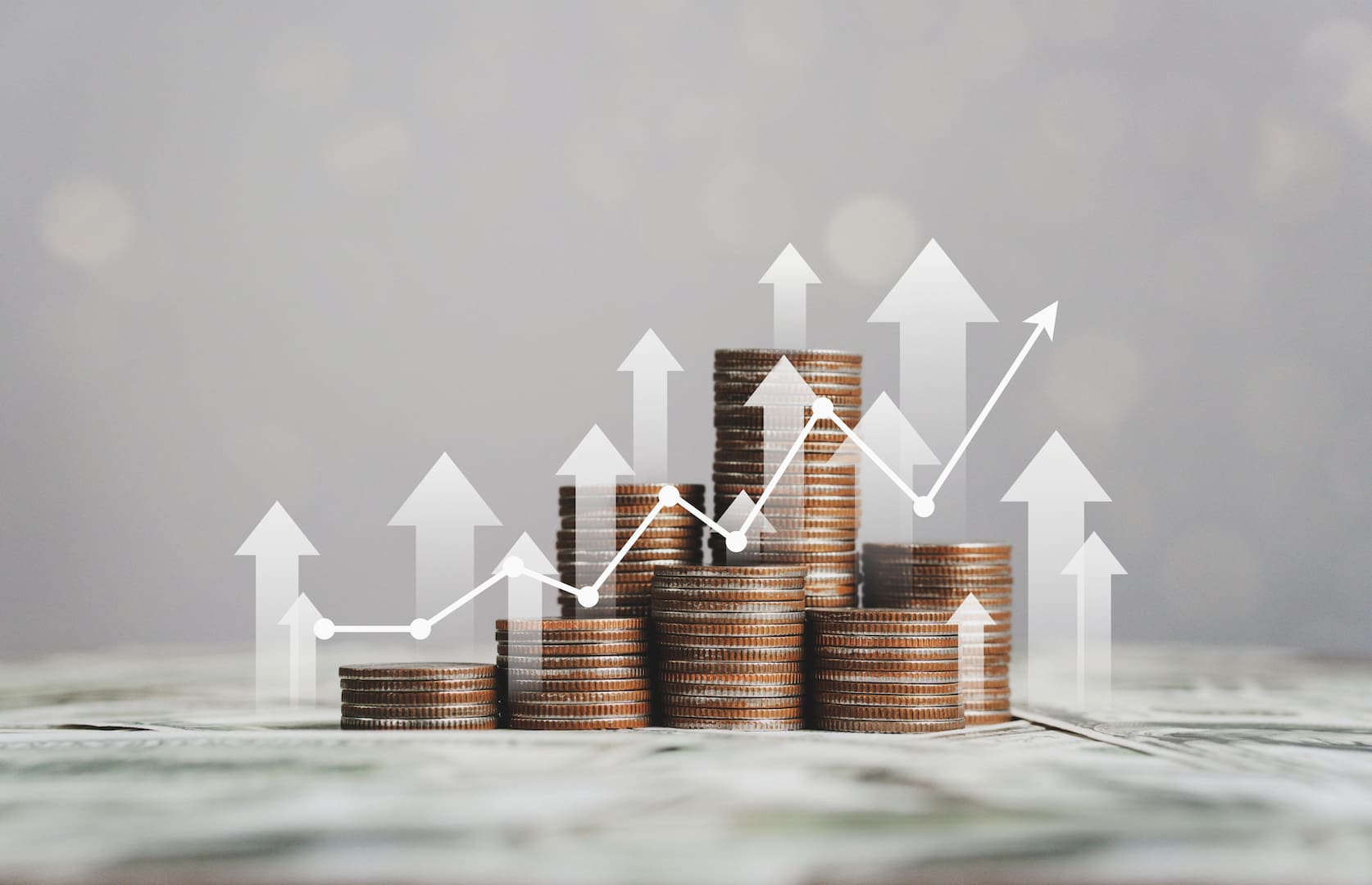 A imagem mostra várias pilhas de moedas com um gráfico de rentabilidade em crescimento, exemplificando os resultados da diversificação de investimentos. (Foto: Shutterstock / d.ee_angelo)