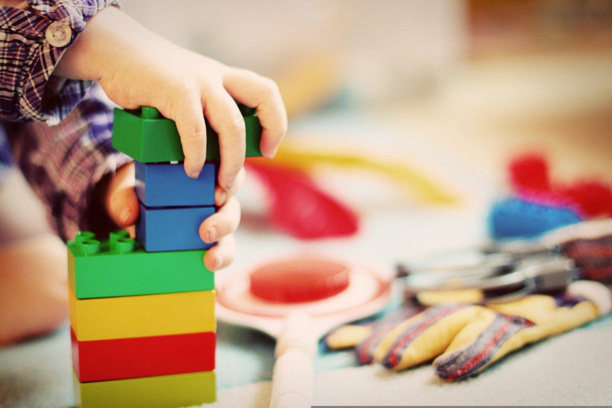 mão de uma criança com peças de Lego