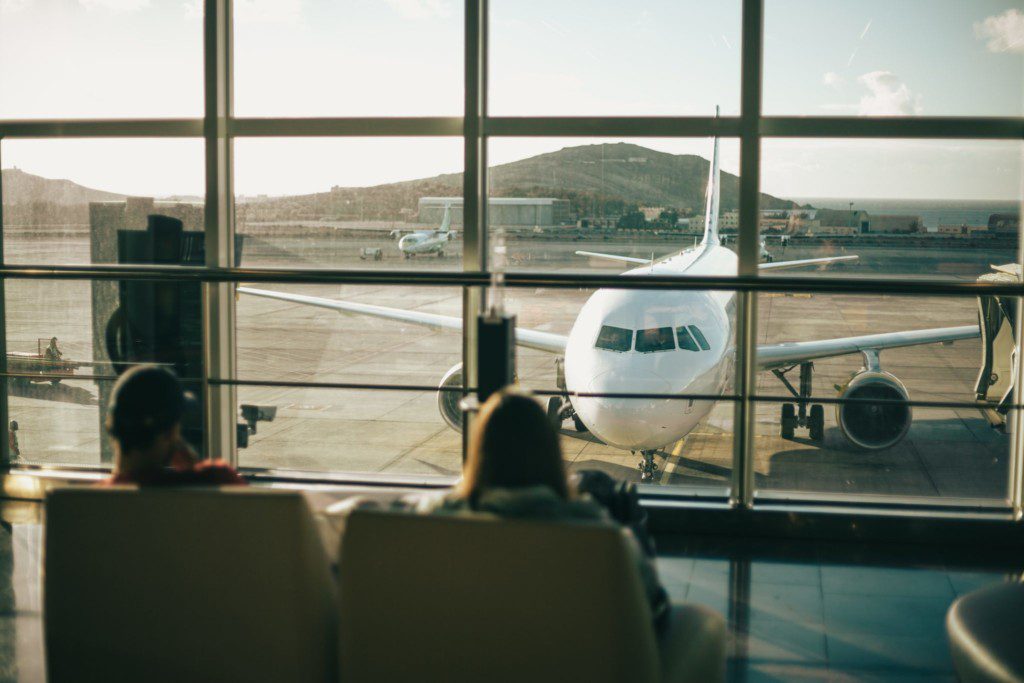 Imagem em um aeroporto com vista da janela para um avião