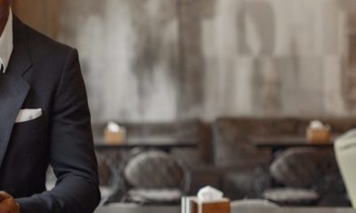 Black man in a black suit standing in a cafe