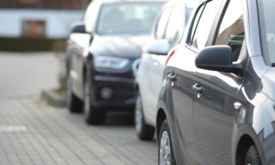 Foto de um carro preto em um estacionamento com o fundo desfocado, representando o refinanciamento de veículos