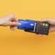 imagem de uma mão fazendo um pagamento com um cartão de crédito por aproximação (contactless)