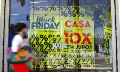 imagem de pessoa andando na rua em frente à loja com escrita "black friday", "casa" e "em até 10x sem juros", ilustrando o tema "black friday"