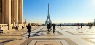 Turistas caminham pela Esplanada no Trocadéro, com vista para a Torre Eiffel em Paris, França