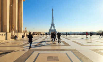 Turistas caminham pela Esplanada no Trocadéro, com vista para a Torre Eiffel em Paris, França