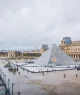 Turistas caminham em frente ao Museu do Louvre em Paris