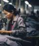 Retrato de mulher asiática costurando roupas em fábrica multinacional, empregos precários, más condições de trabalho, exploração e conceito de fast fashion