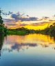 Reflexo de um pôr do sol em uma lagoa dentro da Bacia da Floresta Amazônica. A bacia do rio Amazonas compreende os países Brasil, Bolívia, Colômbia, Equador, Guiana, Suriname, Peru e Venezuela.