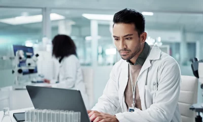 Medico dentro de um laboratorio analisando dados em um computador
