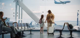 Área de embarque de aeroporto; mãe e filha observam avião decolando; embarque; viagem; turismo; avião