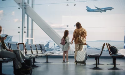 Área de embarque de aeroporto; mãe e filha observam avião decolando; embarque; viagem; turismo; avião