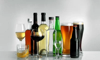 Taças de vinho e garrafas de bebida alcoólica sobre fundo sobre fundo claro