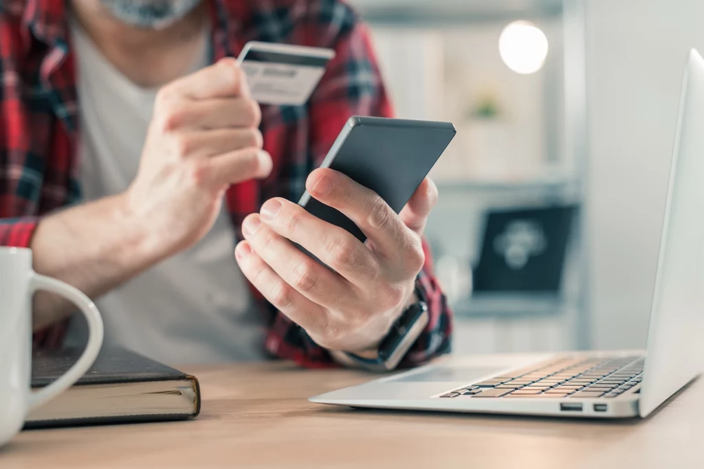 Homem realizando compra online com cartão de crédito; internet banking; app banco