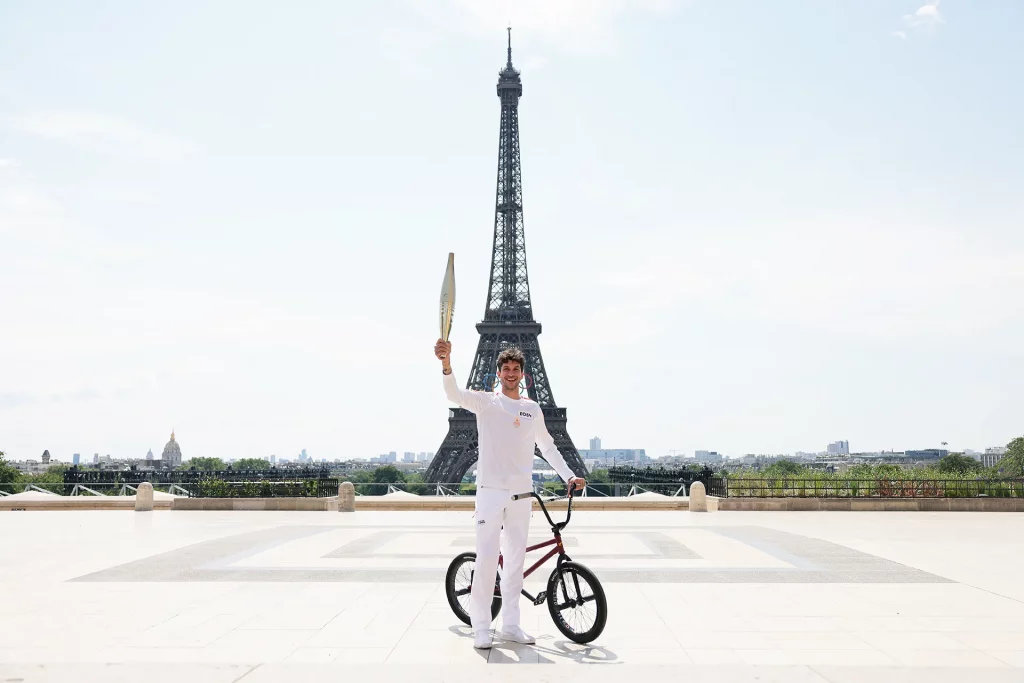 O portador da tocha Matthias Dandois, ciclista francês, posa para uma foto com a Tocha Olímpica na Place du Trocadero com a Torre Eiffel à vista durante o segundo dia do Revezamento da Tocha Olímpica de Paris 2024 em 15 de julho de 2024 em Paris, França. (Foto: Maja Hitij/Getty Images)