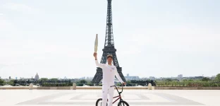 O portador da tocha Matthias Dandois, ciclista francês, posa para uma foto com a Tocha Olímpica na Place du Trocadero com a Torre Eiffel à vista durante o segundo dia do Revezamento da Tocha Olímpica de Paris 2024 em 15 de julho de 2024 em Paris, França. (Foto: Maja Hitij/Getty Images)