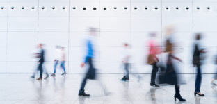 Trabalhadores caminham no lobby de um edifício comercial; trabalho; trabalhadores; emprego