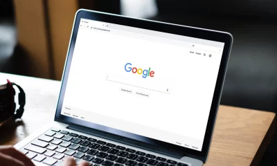 Um homem digitando no mecanismo de busca Google em um laptop