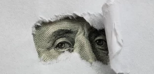 Detalhe de nota de dólar sob papel rasgado