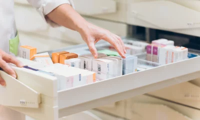 Mão de farmacêutico tirando medicamento da gaveta