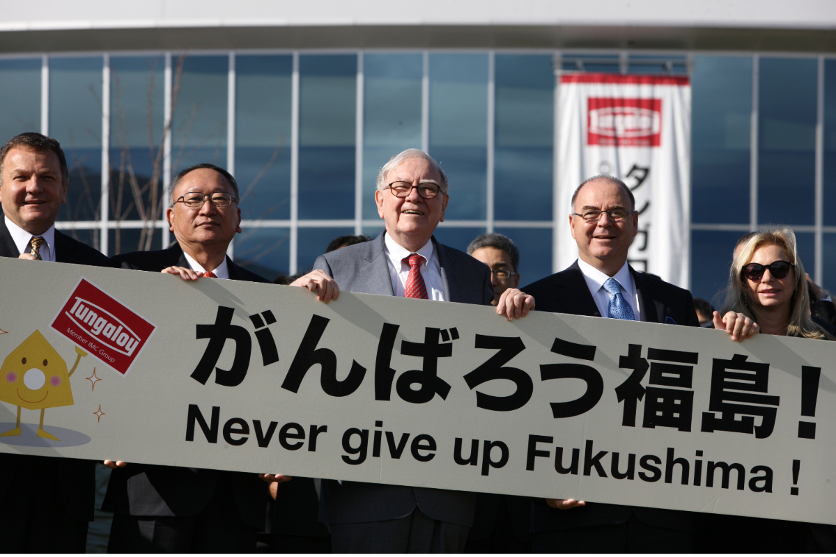 Warren Buffett segura faixa em apoio a Fukushima durante visita ao Japão