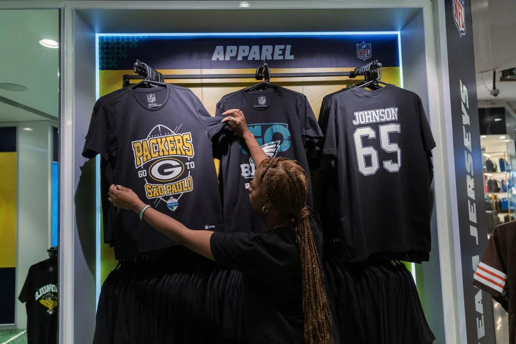 Consumidor olha camiseta em loja de produtos especializada em artigos da NFL