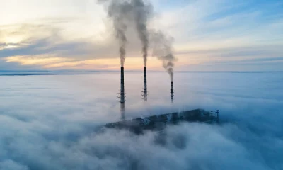 Altas tubulações de usina de carvão com fumaça preta subindo poluindo a atmosfera. Produção de energia elétrica com conceito de combustível fóssil.