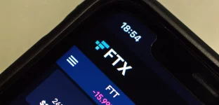 Close-up da tela de um smartphone exibindo a interface do aplicativo de criptomoedas da FTX com atualização em tempo real.