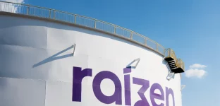 Tanque industrial branco com logotipo "raizen" em roxo, escada lateral e céu azul claro ao fundo.