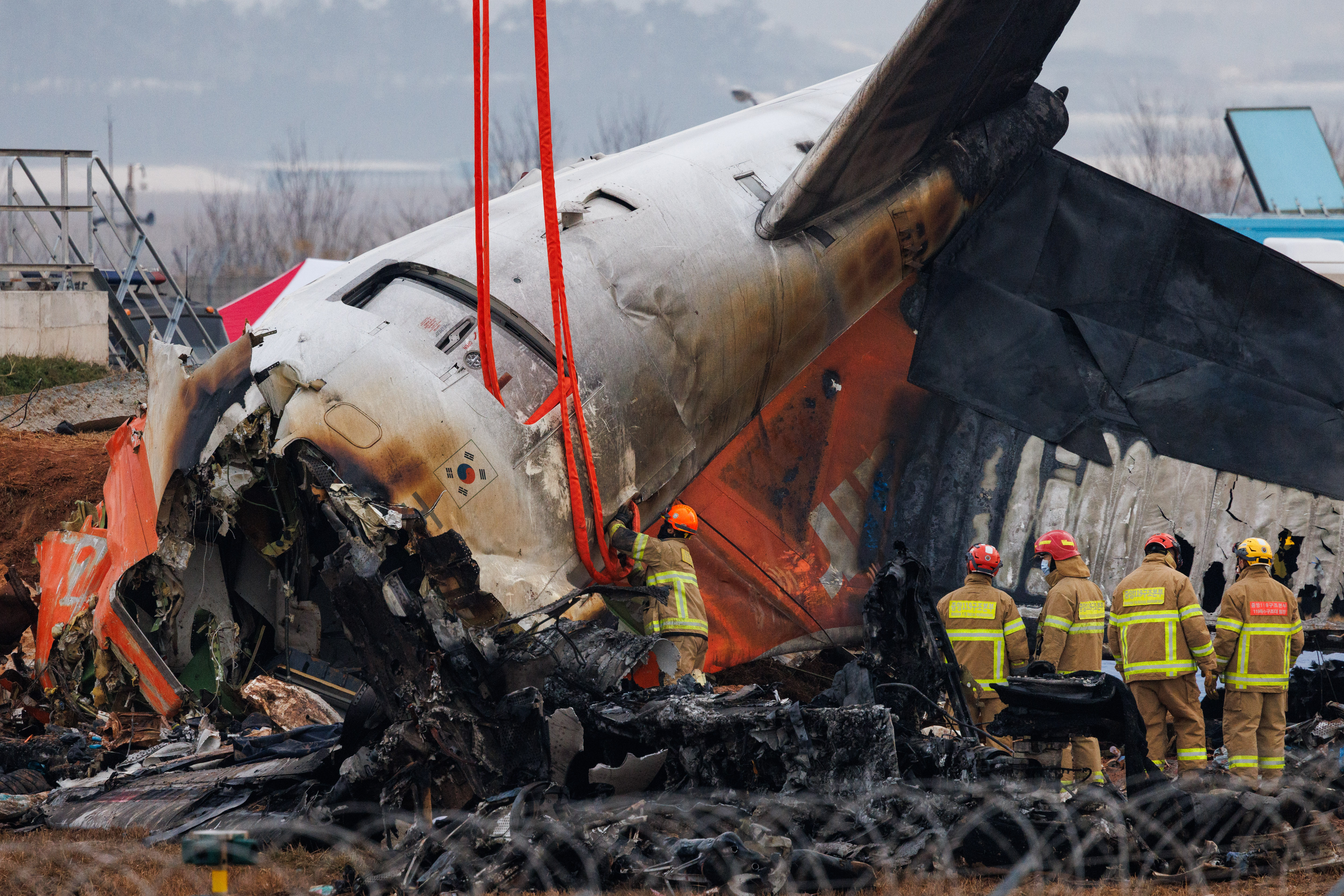 Bombeiros inspecionam destroços do avião da Jeju Air